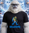 Yeti wearing glasses and a t-shirt with a stylized Oklahoma map design.