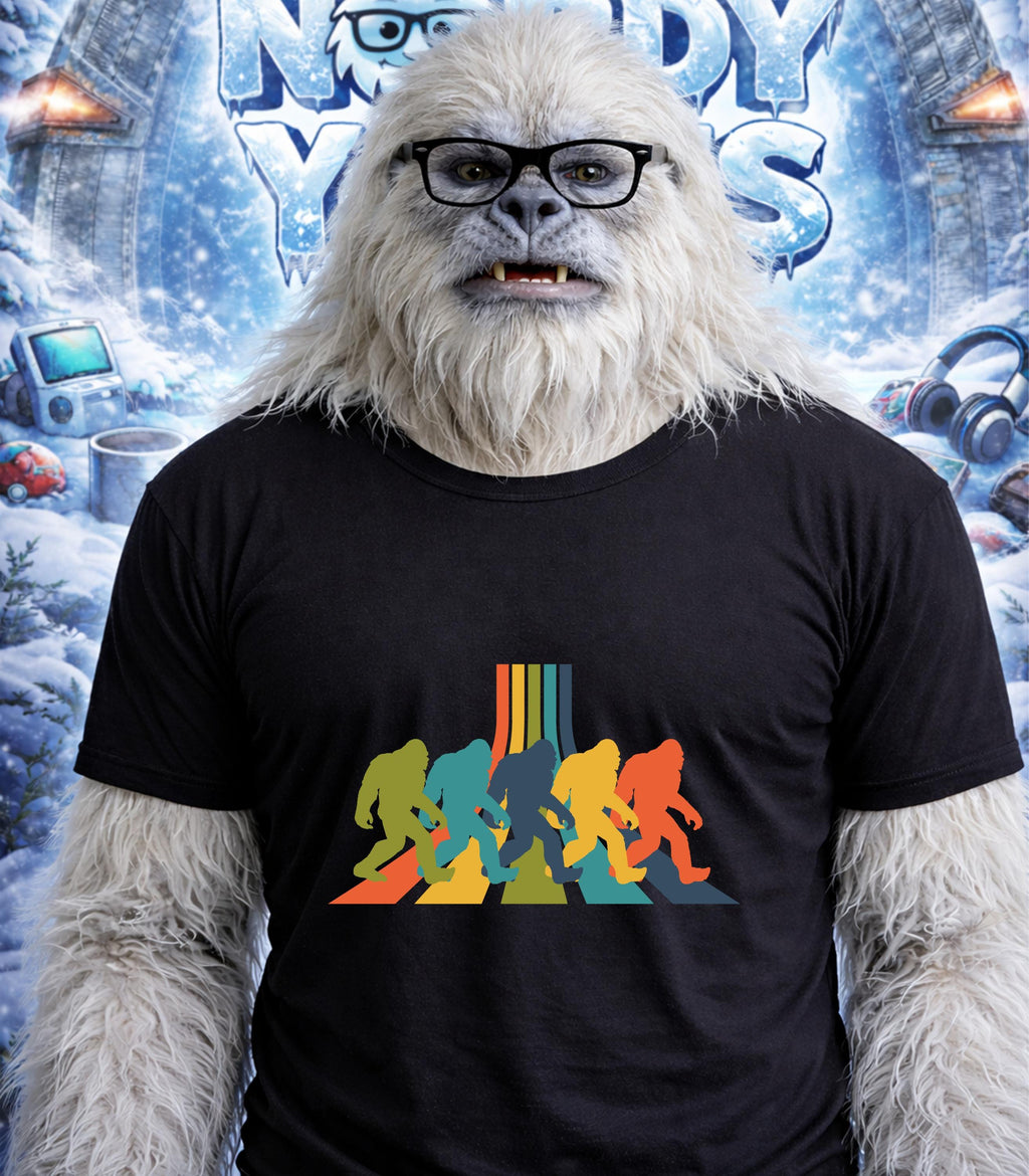 Yeti wearing a t-shirt with colorful Bigfoot silhouettes crossing a road.