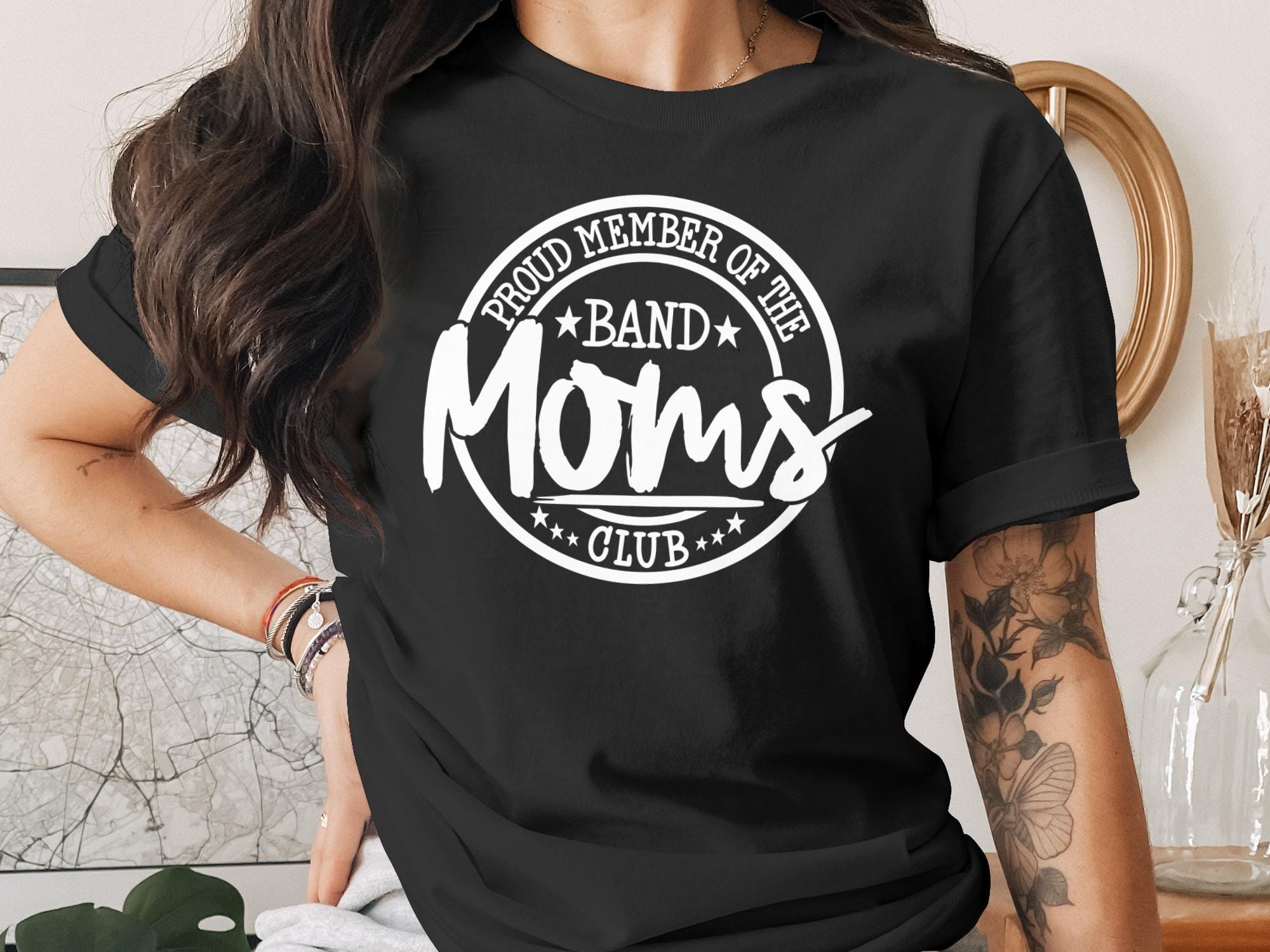 Black t-shirt with "Proud Member of the Moms Club" text and star graphics.