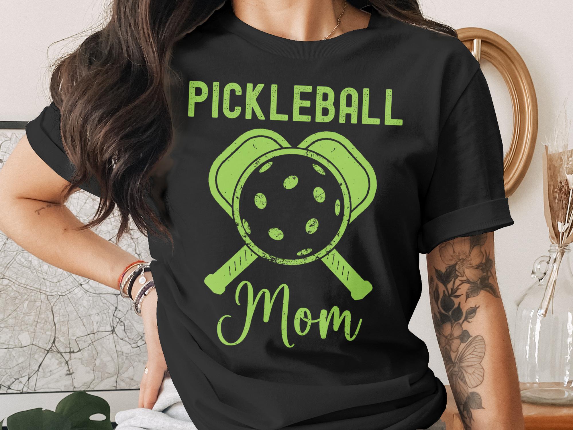 Green "Pickleball Mom" text with pickleball paddles and ball graphic.