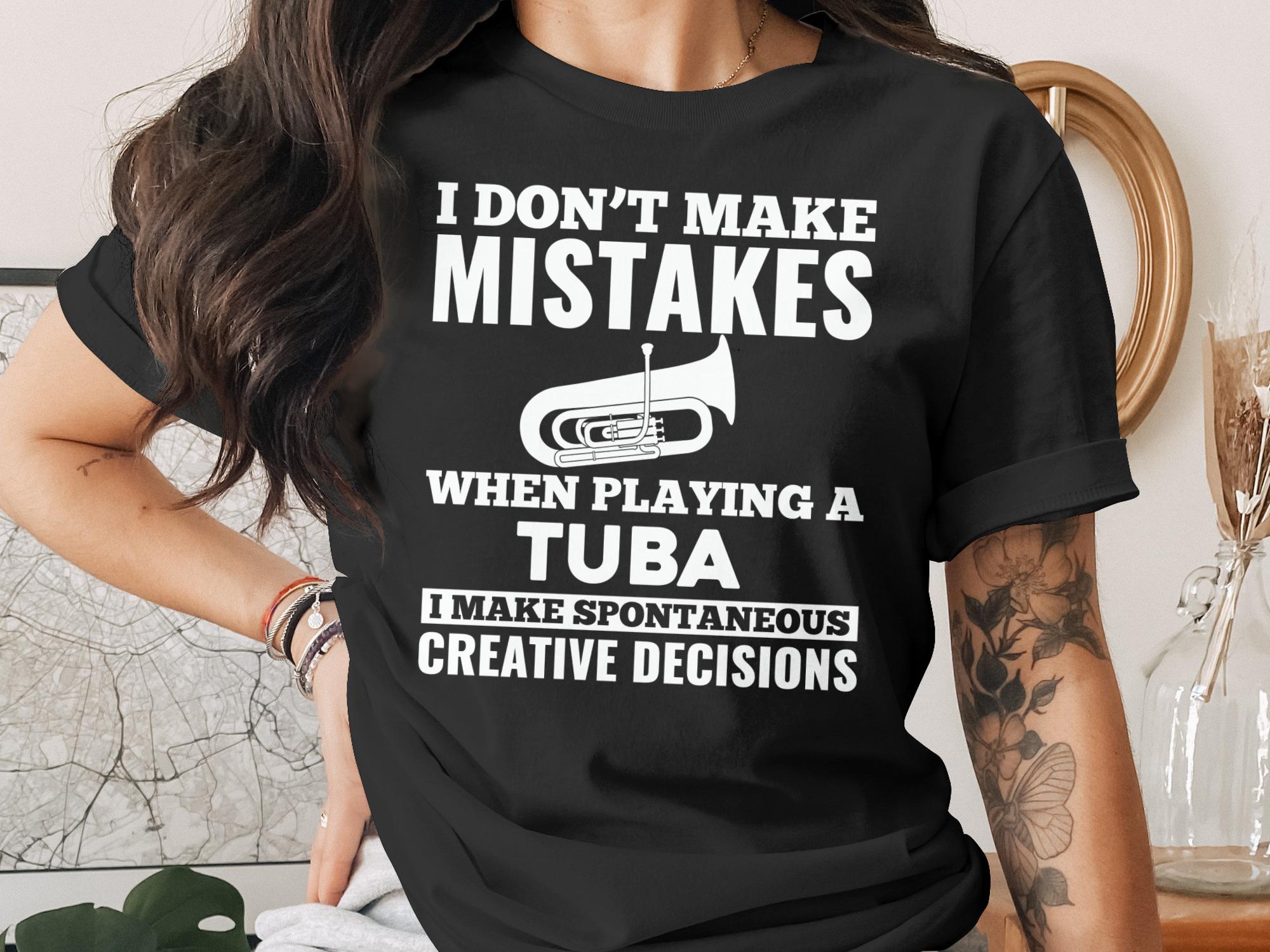 Black t-shirt with white text "I Don't Make Mistakes When Playing A Tuba, I Make Spontaneous Creative Decisions" and tuba graphic.