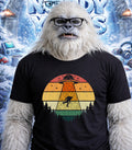 Yeti wearing glasses and a t-shirt with a retro alien abduction design.