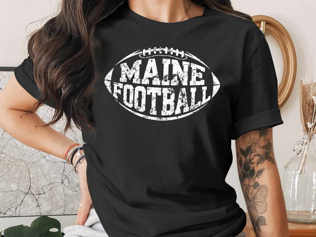 Black t-shirt with "Maine Football" text in a football shape.