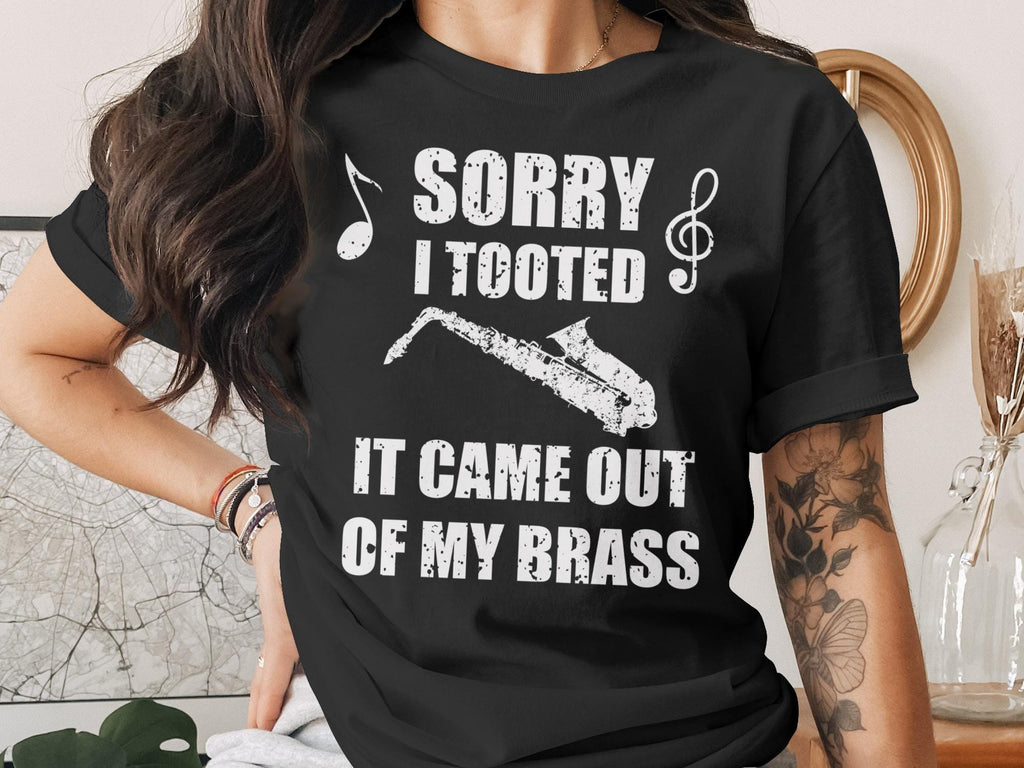 Black t-shirt with white text and saxophone graphic reading "Sorry I Tooted It Came Out Of My Brass".