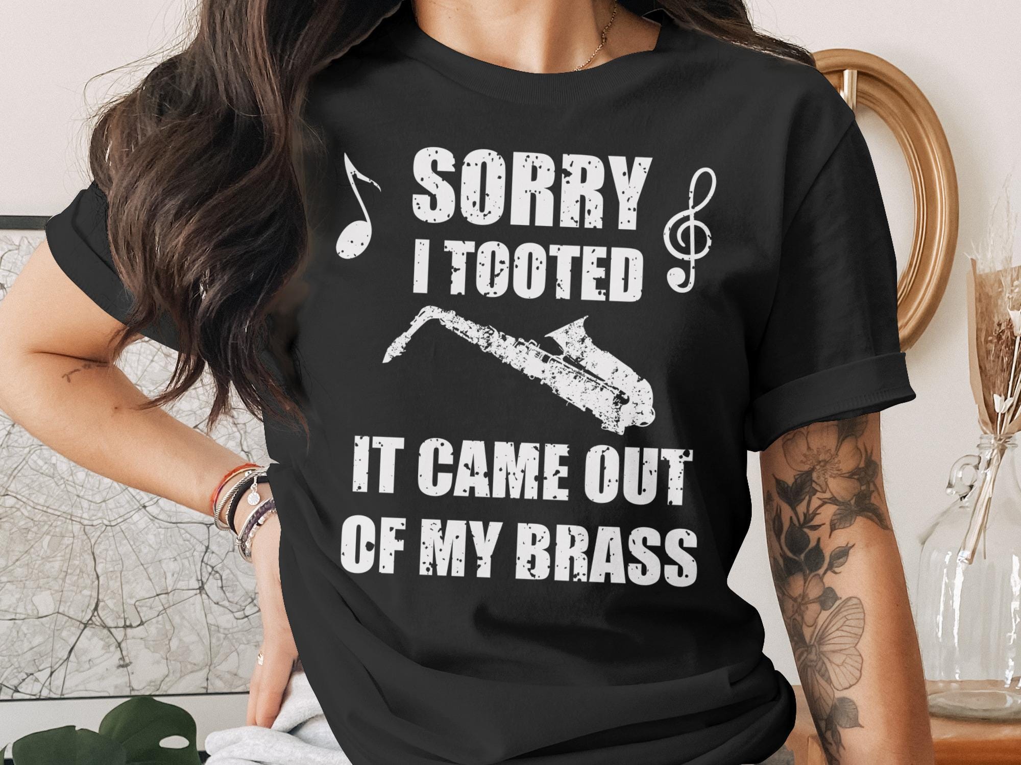 Black t-shirt with white text and saxophone graphic reading "Sorry I Tooted It Came Out Of My Brass".