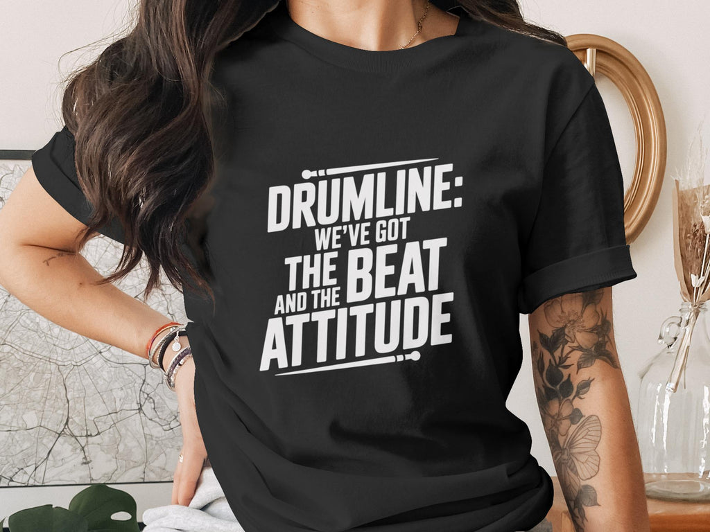Black t-shirt with white text "DRUMLINE: WE'VE GOT THE BEAT AND THE ATTITUDE".
