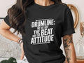 Black t-shirt with white text "DRUMLINE: WE'VE GOT THE BEAT AND THE ATTITUDE".