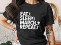 Black t-shirt with "Eat. Sleep. March. Repeat." text and marching band silhouettes.