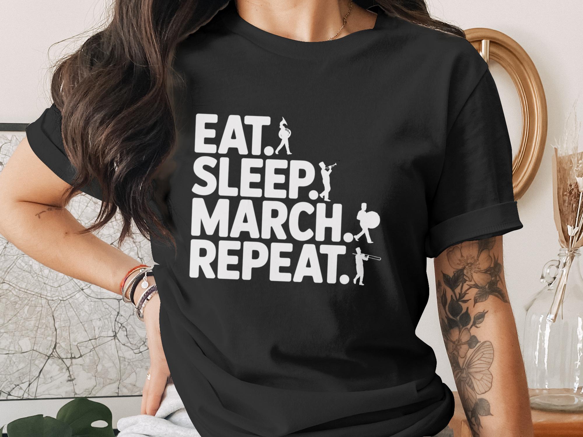 Black t-shirt with "Eat. Sleep. March. Repeat." text and marching band silhouettes.