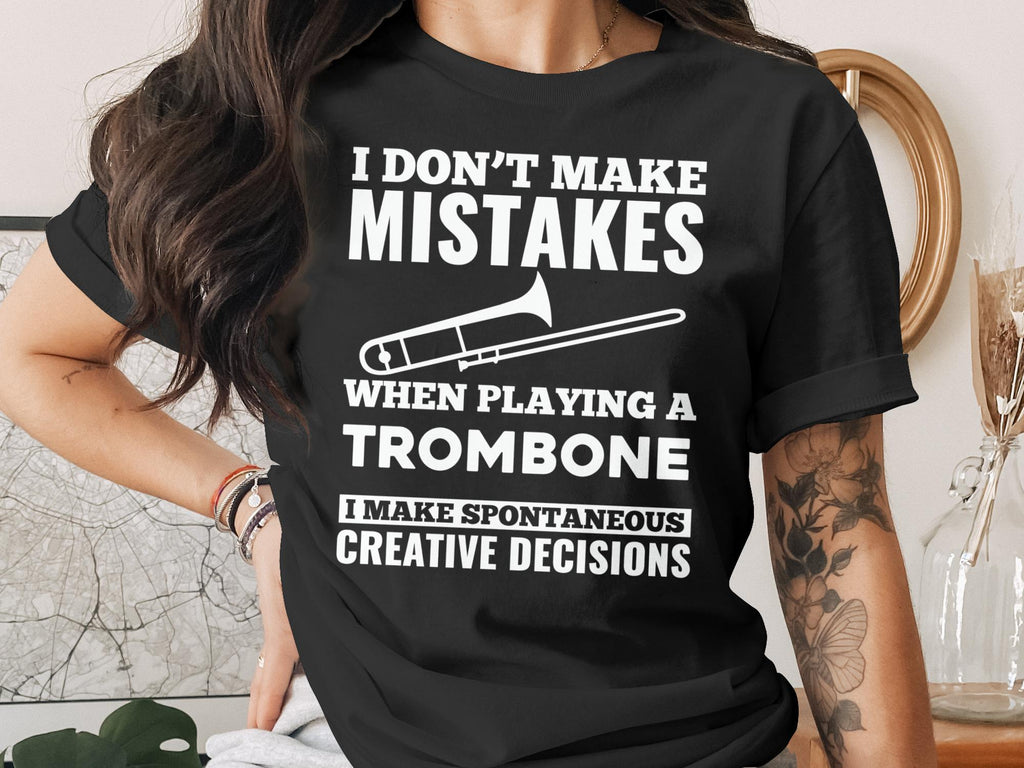 Black t-shirt with white text and trombone graphic reading "I Don't Make Mistakes When Playing a Trombone I Make Spontaneous Creative Decisions".