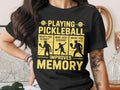 Black t-shirt with text "Playing Pickleball Improves Memory" and pickleball players.