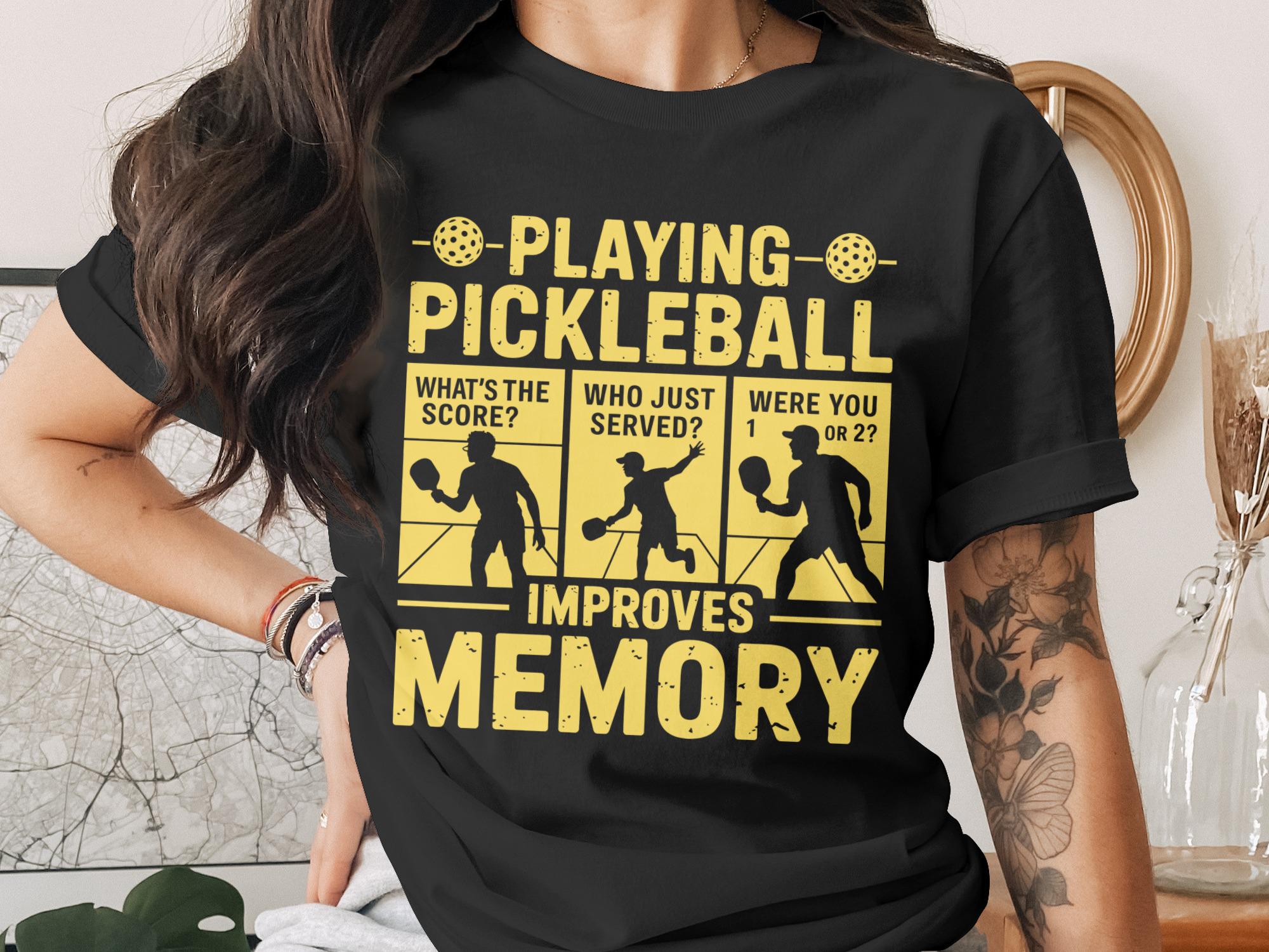 Black t-shirt with text "Playing Pickleball Improves Memory" and pickleball players.