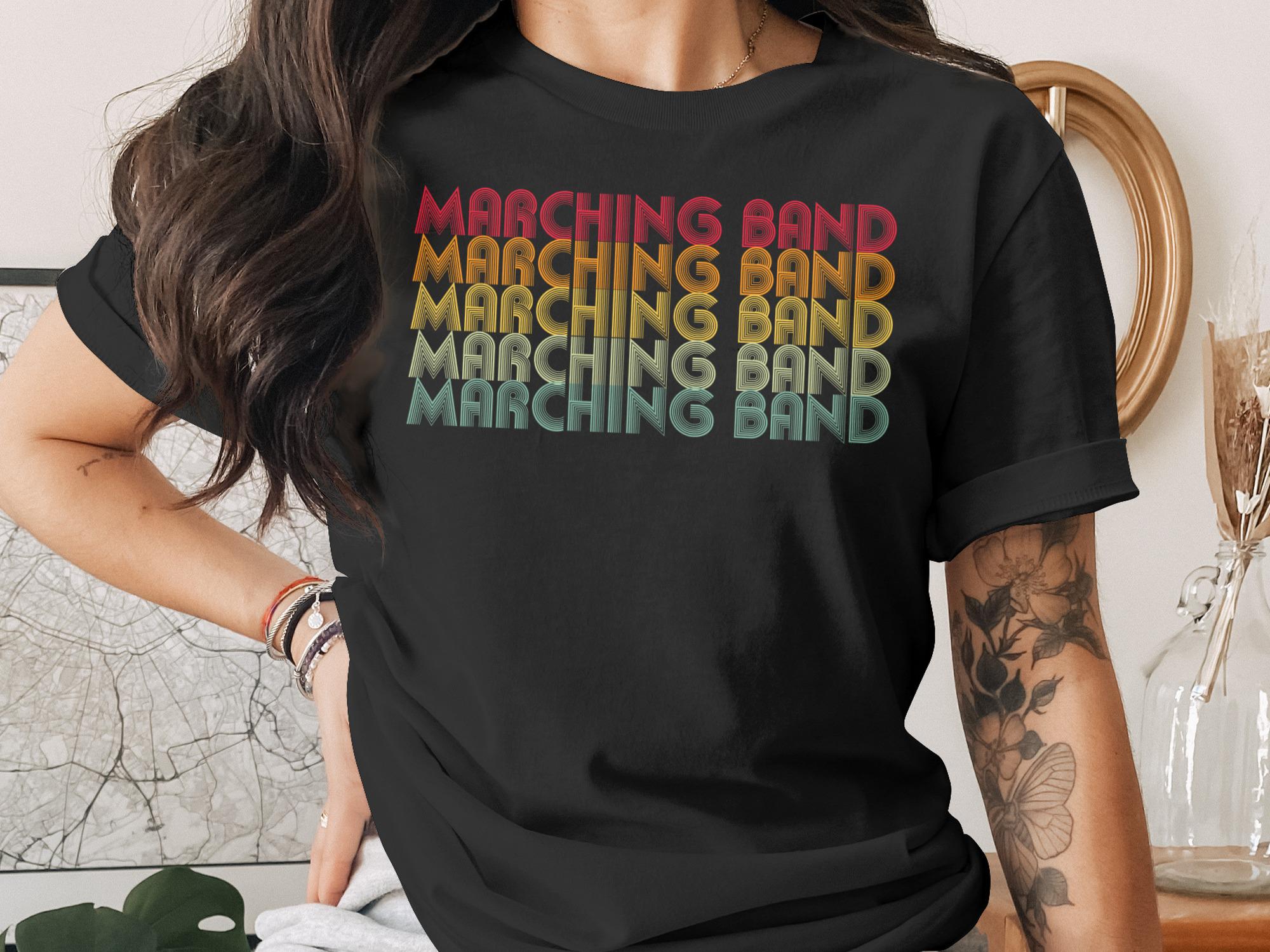 Black t-shirt with "MARCHING BAND" text in a retro gradient.