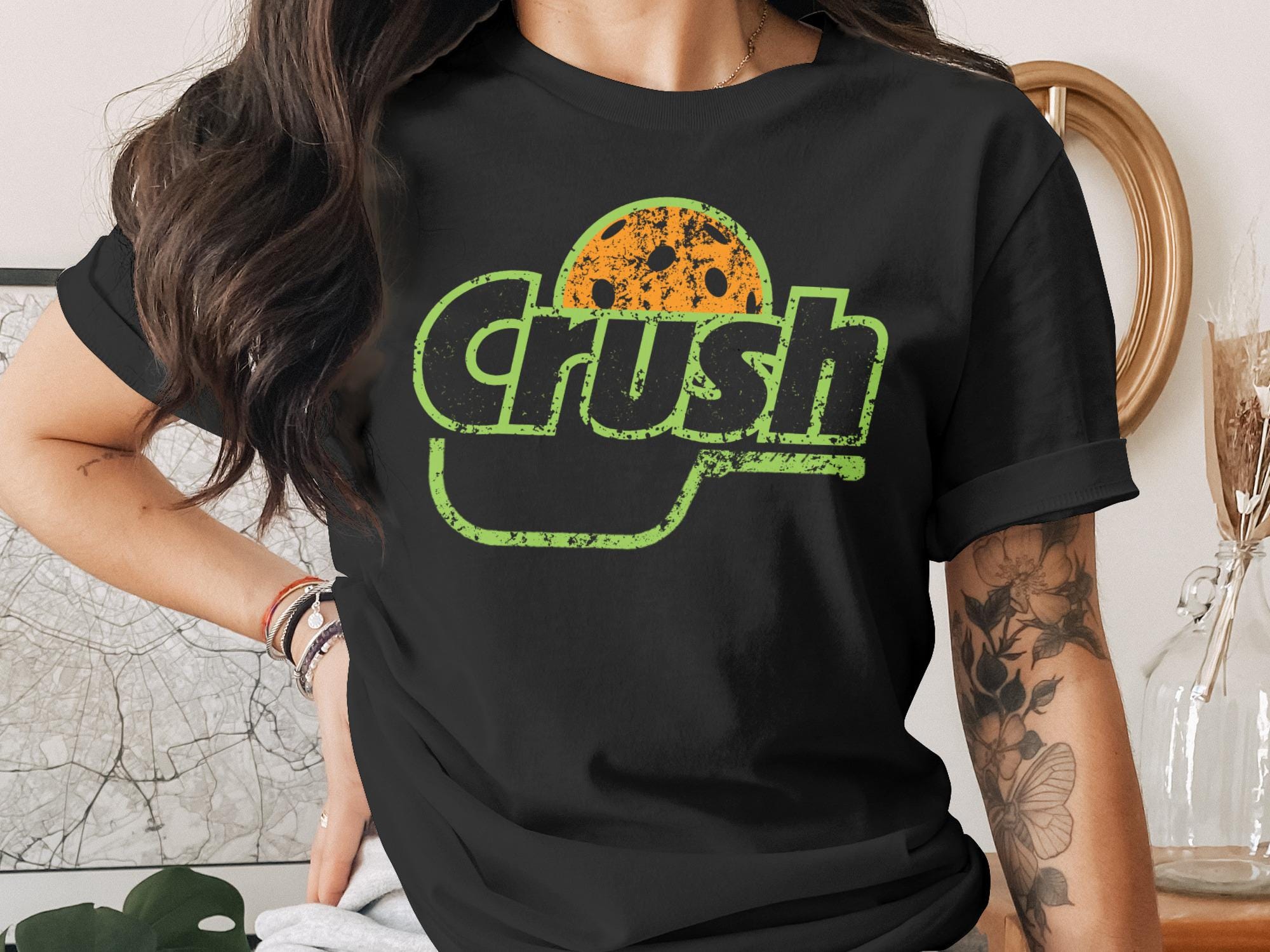 T-shirt with green "Crush" logo and orange polka dot pattern.