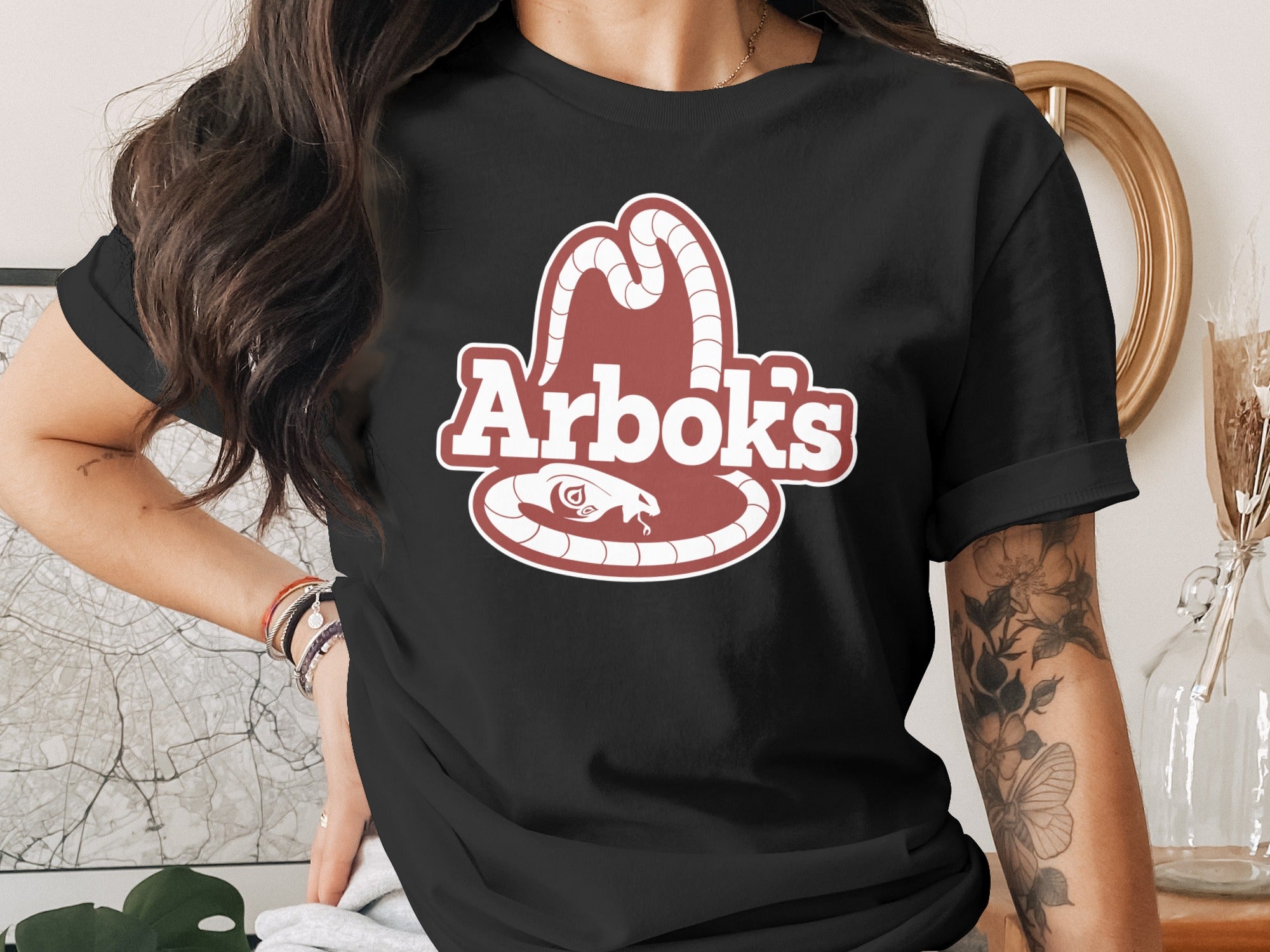 Black t-shirt with Arbok logo featuring a snake and cowboy hat.