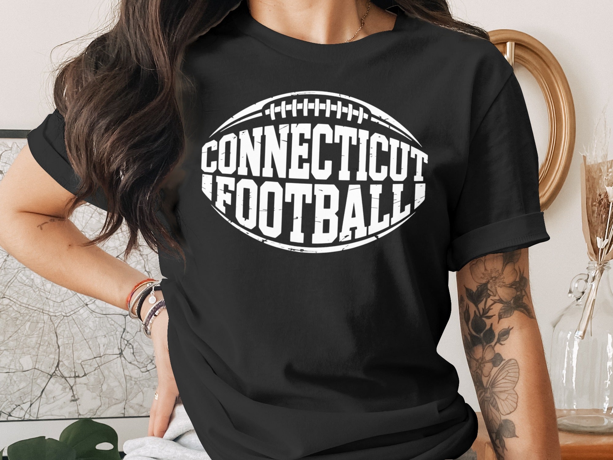 Black t-shirt with white "Connecticut Football" text in a football outline.