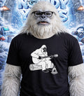 Yeti wearing glasses and t-shirt with yeti playing guitar on log graphic.