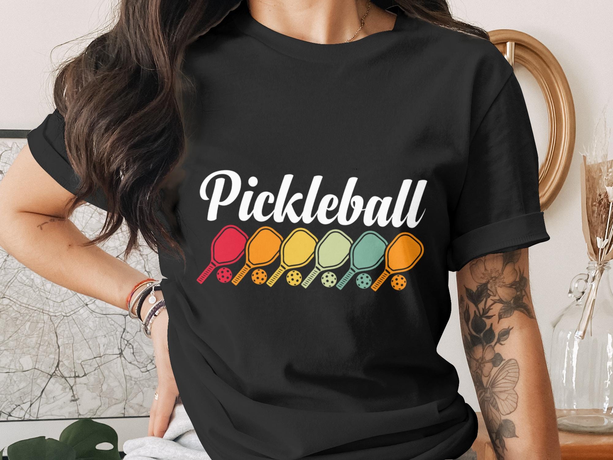 Black t-shirt with colorful pickleball paddles and "Pickleball" text.