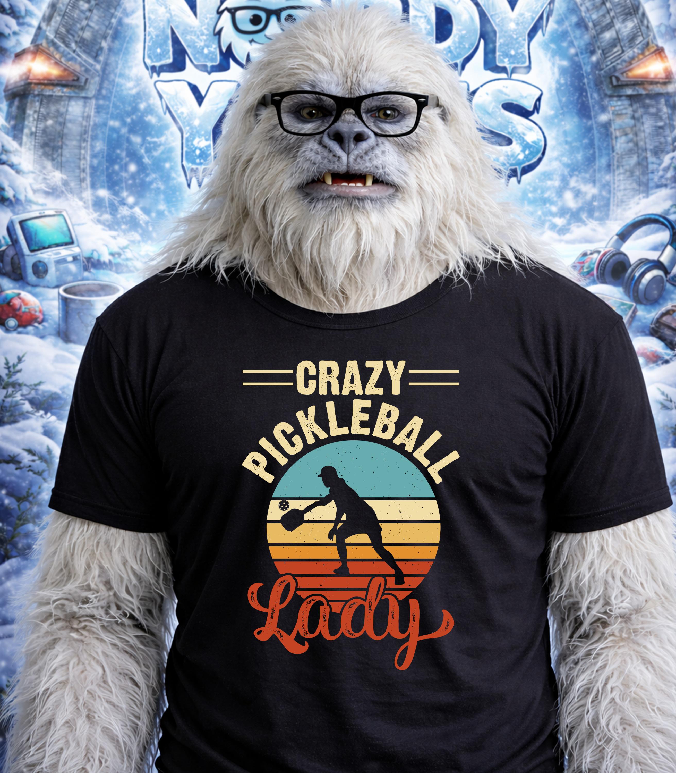 Yeti wearing t-shirt reading "Crazy Pickleball Lady" with sunset graphic.