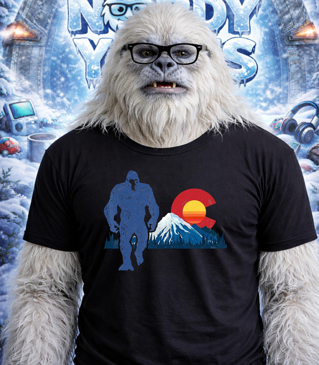 Yeti wearing glasses and a t-shirt with a blue Bigfoot and Colorado flag design.