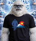 Yeti wearing glasses and a t-shirt with a blue Bigfoot and Colorado flag design.