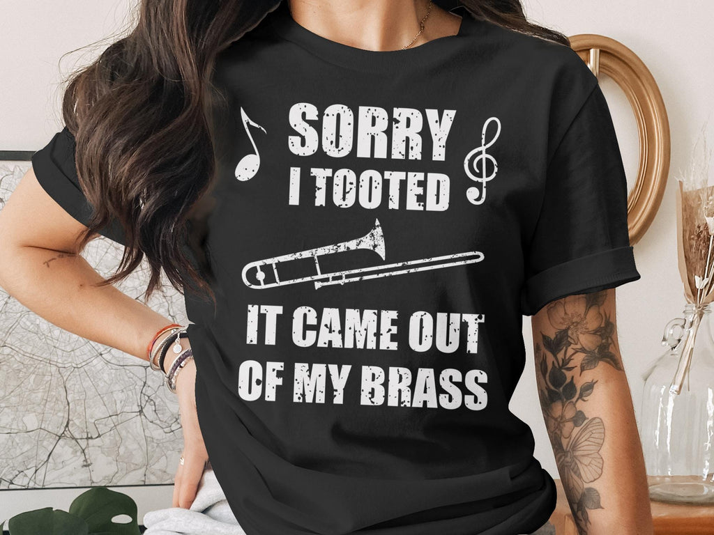 Black t-shirt with "Sorry I Tooted It Came Out Of My Brass" and trombone graphic.