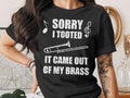 Black t-shirt with "Sorry I Tooted It Came Out Of My Brass" and trombone graphic.