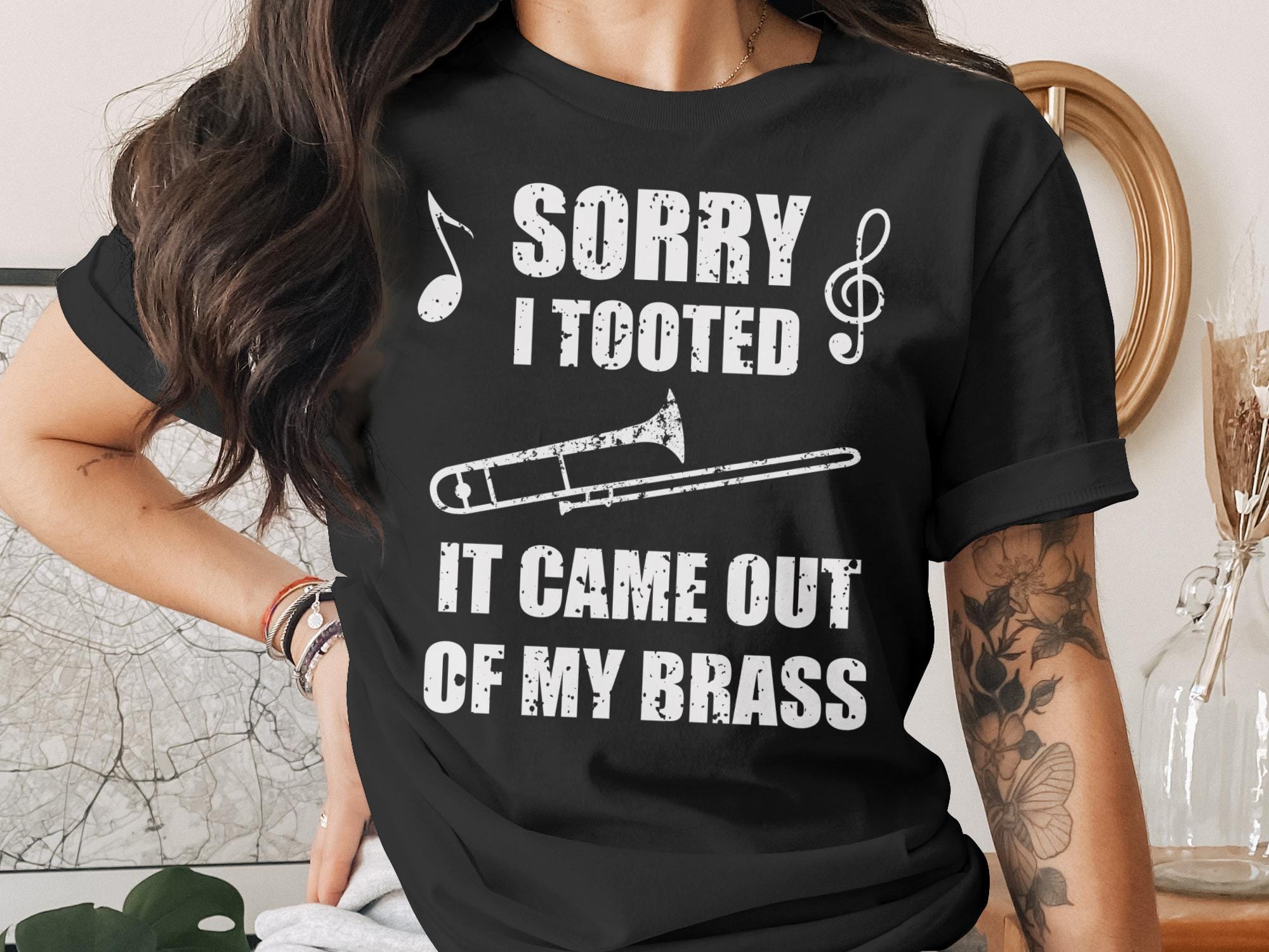 Black t-shirt with "Sorry I Tooted It Came Out Of My Brass" and trombone graphic.