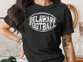 Black t-shirt with white "DELAWARE FOOTBALL" text and football graphic.