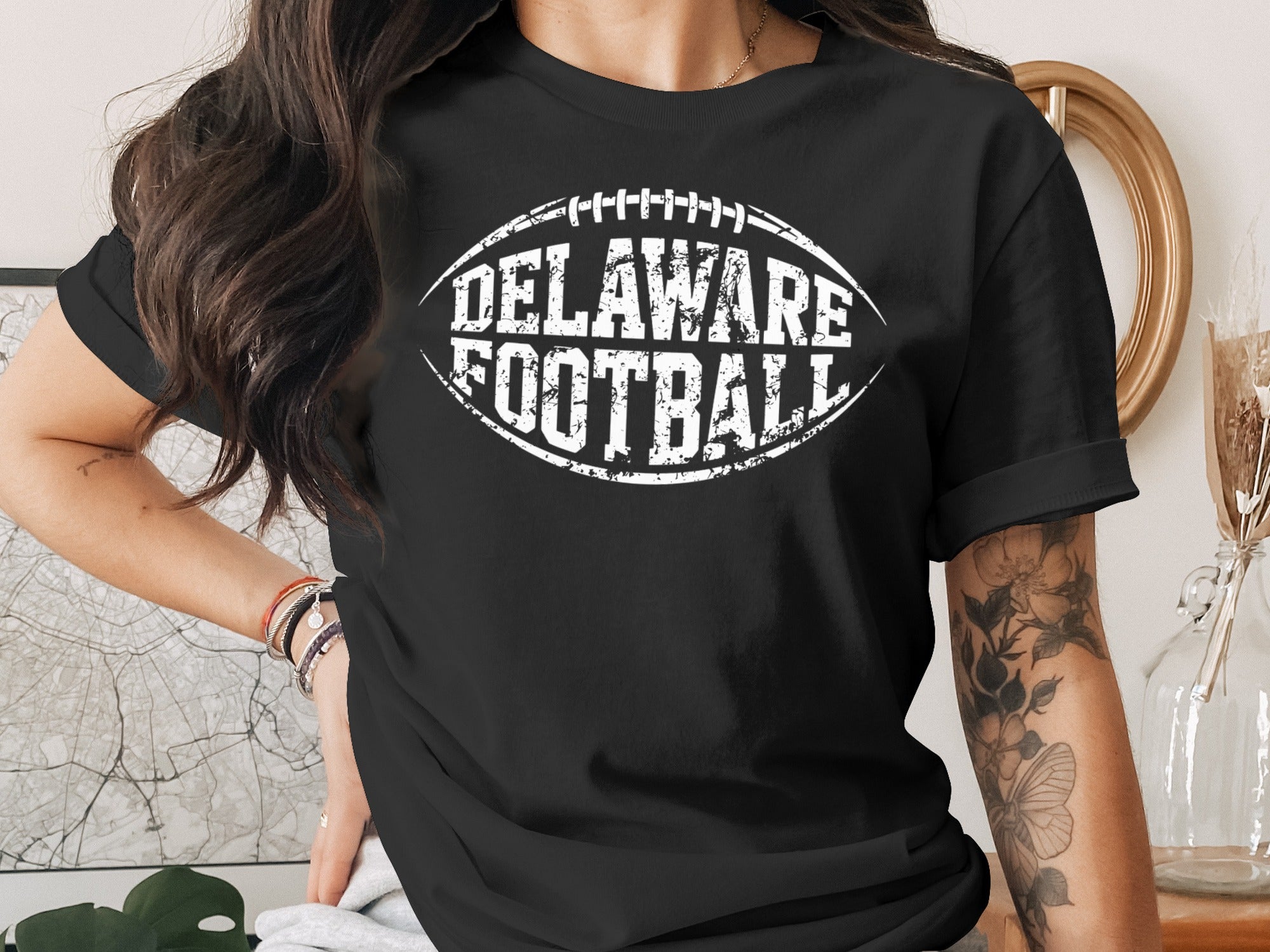 Black t-shirt with white "DELAWARE FOOTBALL" text and football graphic.
