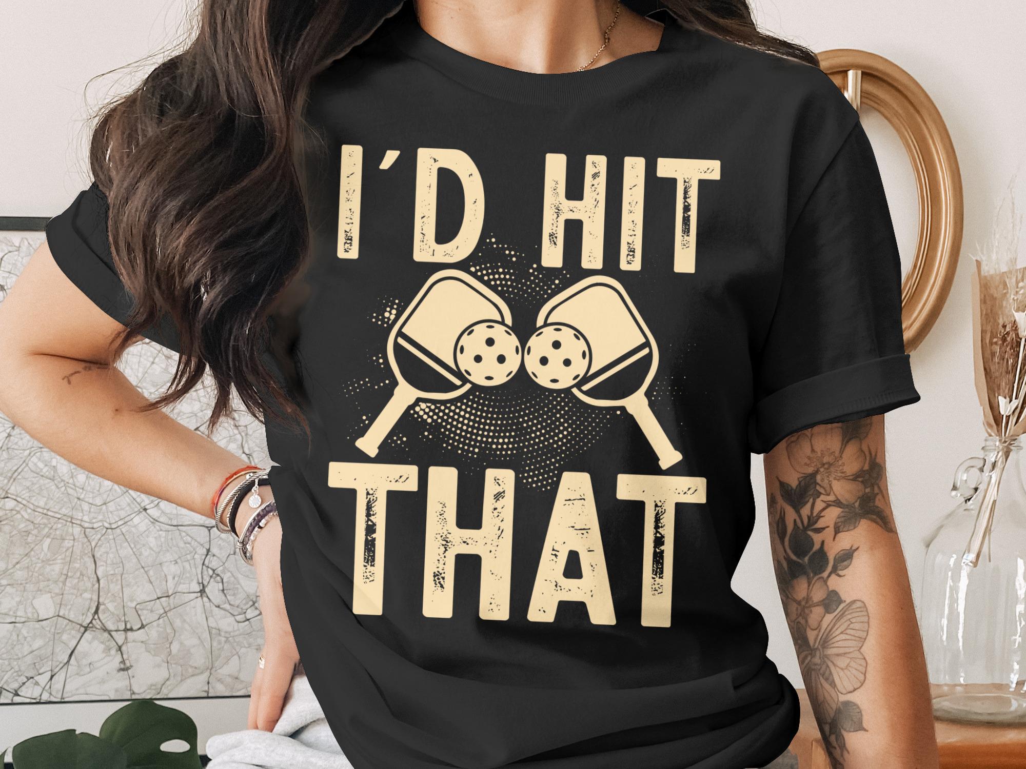 Black t-shirt with "I'D HIT THAT" and crossed pickleball paddles graphic.