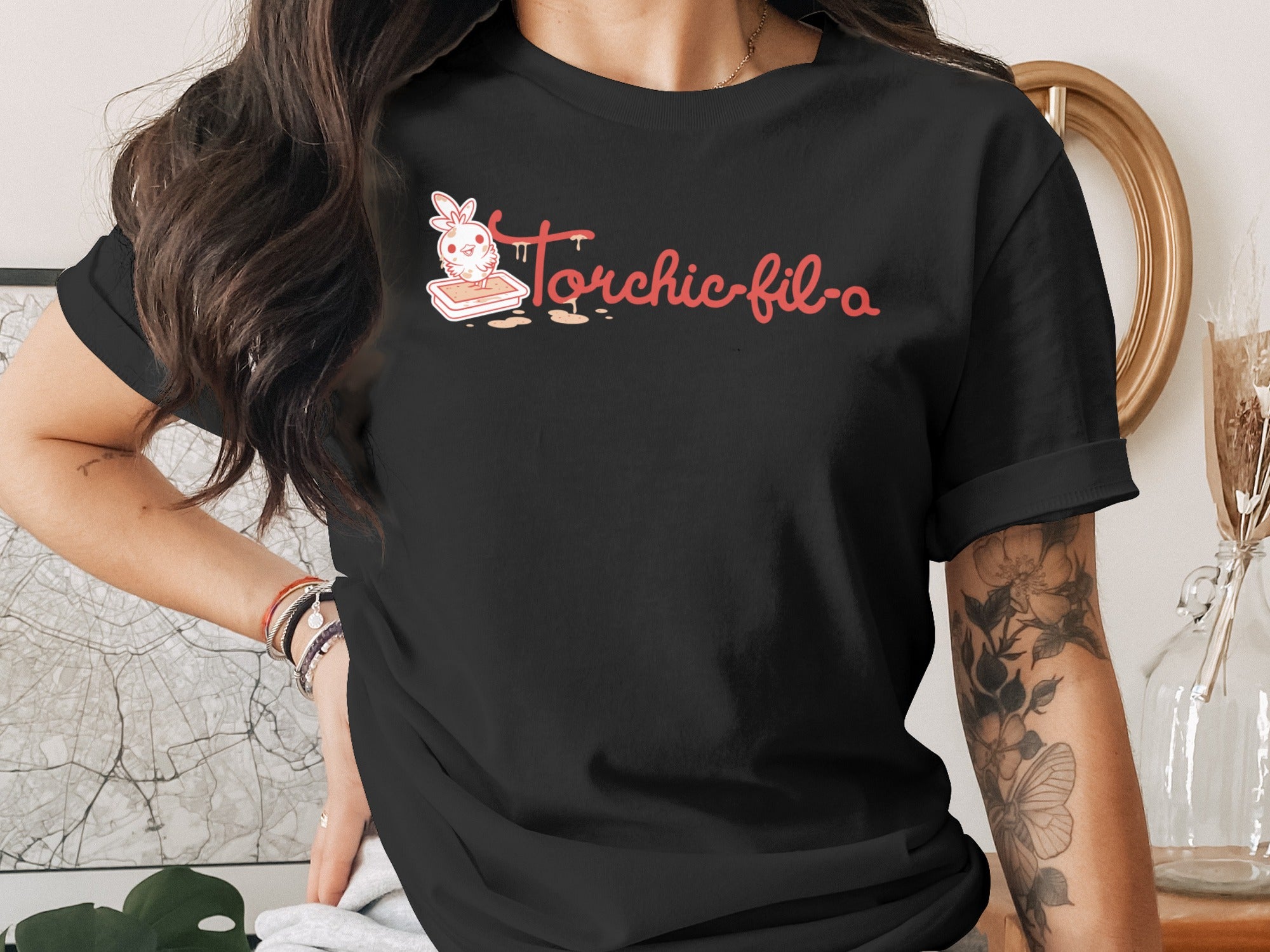 Black t-shirt with "Torchic-fil-a" text and a cartoon bunny in a box.