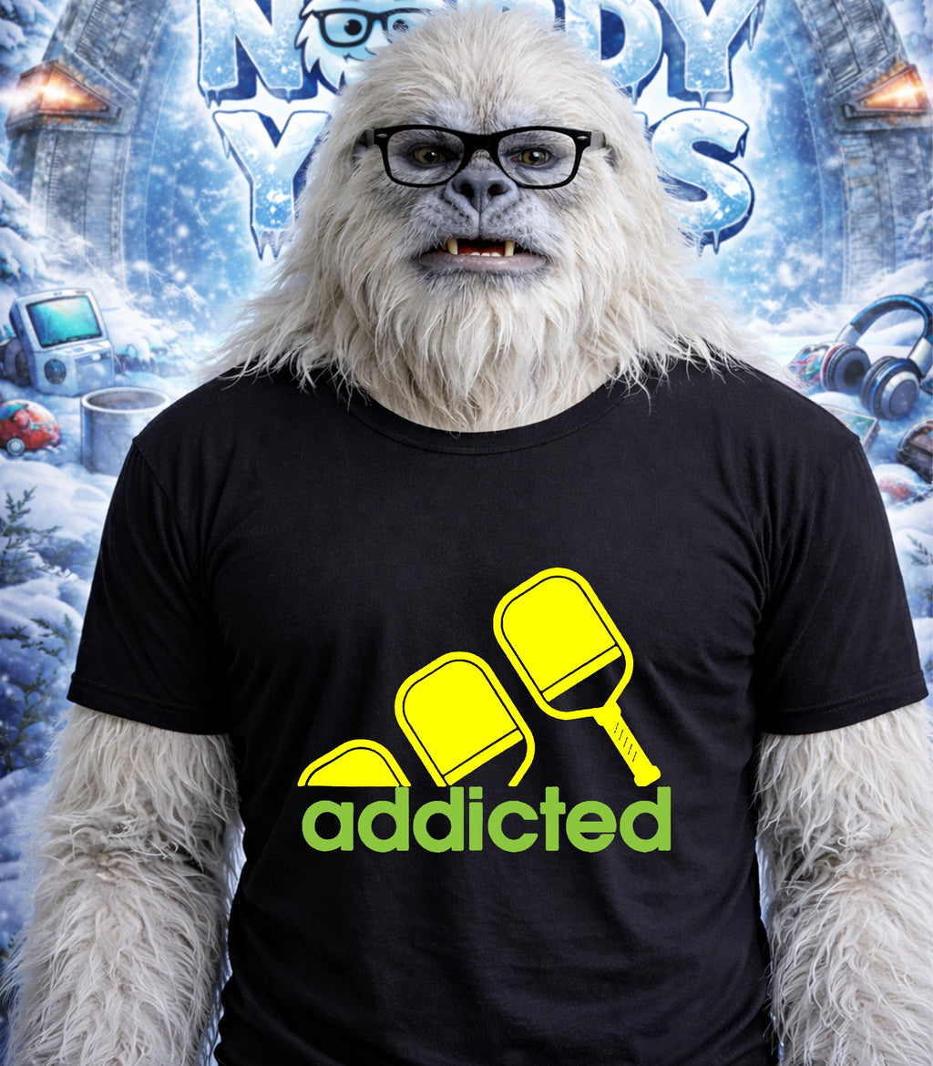 Yeti wearing glasses and a t-shirt with "addicted" and pickleball paddles.